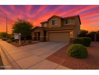 Beautiful two-story home featuring desert landscaping and a two car garage at dusk with colorful skies at 6632 W Saguaro Park Ln, Glendale, AZ 85310