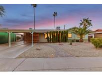 Charming single-story home featuring a covered carport, desert landscaping, and a brick pathway leading to the entrance at 6932 E Latham St, Scottsdale, AZ 85257