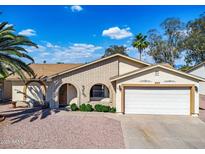 Charming single-story home featuring a two-car garage, brick accents, and a well-maintained front yard at 811 S 79Th Way, Mesa, AZ 85208