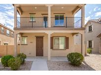Inviting two-story home with a balcony, desert landscaping, and a cozy front entrance at 925 E Agua Fria Ln, Avondale, AZ 85323