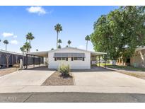 Charming single-story home with covered parking and a well-maintained front yard with lush green trees at 9501 E Broadway Rd # Ofc, Mesa, AZ 85208