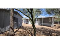 A community of gray homes with covered carports and light-colored entry stairs, and desert landscaping at 9632 E Arbor Cir, Mesa, AZ 85208