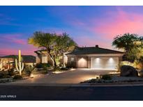 Stunning home exterior boasts desert landscaping and a spacious driveway leading to a two-car garage at 9675 E Roadrunner Dr, Scottsdale, AZ 85262