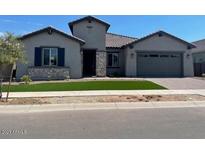 Charming single-story home featuring desert landscaping, a two-car garage, and a stone-accented facade at 16035 W Questa Dr, Surprise, AZ 85387