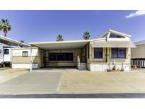 Charming mobile home exterior with carport, low maintenance yard, and sunny desert landscape at 17200 W Bell Rd # 47, Surprise, AZ 85374