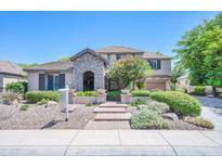 Charming two-story home features a stone archway, lush landscaping, and a welcoming entryway at 2383 E Zion Way, Chandler, AZ 85249