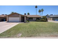 Charming single-story home featuring a well-manicured lawn, attached garage, and desert landscaping at 3633 W Redfield Rd, Phoenix, AZ 85053