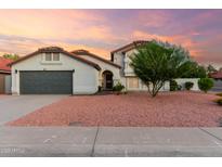 Charming single-Gathering home featuring a well-kept lawn and a gray garage door at sunset at 47 W Calle Monte Vis, Tempe, AZ 85284