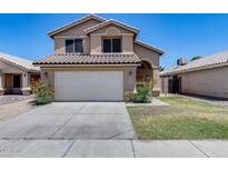 Charming two-story home featuring a tile roof, a two-car garage, and a well-maintained front yard with lovely flowers at 4948 W Wikieup Ln, Glendale, AZ 85308
