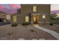 Inviting two-story home featuring a neutral stucco facade and tile roof, complemented by a gravel yard and charming entryway at 8253 W Illini St, Phoenix, AZ 85043