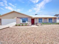Cozy single-Gathering home with a xeriscaped front yard, brick exterior, two-car garage, and well-maintained landscaping at 13810 N 39Th Ave, Phoenix, AZ 85053