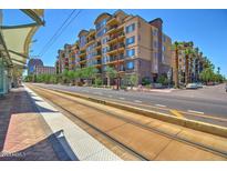 Condo exterior by trolley stop with palm trees and commercial space below at 16 W Encanto Blvd # 26, Phoenix, AZ 85004