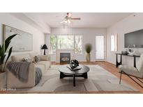 Bright living room featuring a fireplace, ceiling fan, and large windows providing ample natural light at 16 W Encanto Blvd # 26, Phoenix, AZ 85003
