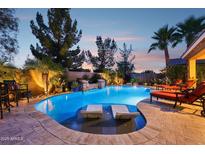 Resort-style pool featuring dual waterfalls, Baja shelf, and mature desert landscaping at 19002 N Arbor Dr, Maricopa, AZ 85138
