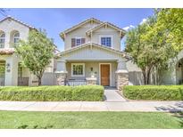 Charming two-story home featuring a welcoming front porch with stone accents and manicured landscaping at 3893 E Gideon Way, Gilbert, AZ 85296