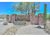 Stone sign for Scarlet Canyon community with desert landscaping, including cacti and trees under a bright blue sky at 1623 E Runion Dr, Phoenix, AZ 85024