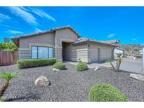 Charming single-story home with neutral stucco, tile roof, two-car garage, and low-maintenance desert landscaping at 1623 E Runion Dr, Phoenix, AZ 85024