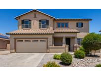 A two-story home with a two-car garage, tiled roof, desert landscaping, and covered entry at 16450 W Lilac St, Goodyear, AZ 85338