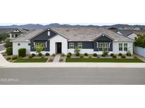 Charming single-story home featuring a well-manicured lawn and a mix of modern white and grey exterior paint at 17146 W Mountainair St, Surprise, AZ 85388