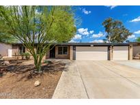 Charming single-story home featuring desert landscaping, a two-car garage, and a brick facade at 19013 N 18Th Ave, Phoenix, AZ 85027