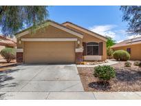 Single-story home with a two-car garage and manicured landscaping offering curb appeal at 23749 W Grove St, Buckeye, AZ 85326