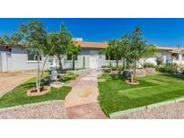 Charming front yard with lush lawn, fountain, mature trees, and welcoming walkway to the front door at 2908 N 54Th Dr, Phoenix, AZ 85031