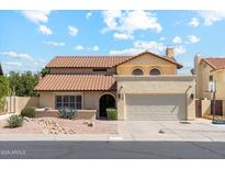Charming stucco home features a red tile roof, two-car garage, and well-maintained landscaping at 438 E Larkspur Ln, Tempe, AZ 85288