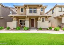 Charming two-story home with a manicured lawn, covered porch, and neutral color palette in a residential neighborhood at 5840 E Holmes Ave, Mesa, AZ 85206