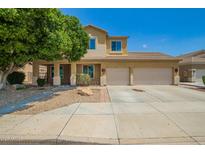 Inviting two-story home with a two-car garage, desert landscaping, and charming front porch at 12950 W Alegre Dr, Litchfield Park, AZ 85340