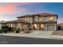 Stunning two-story home featuring a neutral color, tile roof, manicured lawn, and attached two-car garage at 13634 W San Miguel Ave, Litchfield Park, AZ 85340