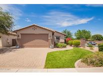 Inviting single-story home featuring a well-manicured lawn, paver driveway, and an attached two-car garage at 1410 W Popcorn Tree Ave, Queen Creek, AZ 85140