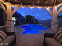 Inviting backyard pool under a covered patio, perfect for evening relaxation at 18195 W Marshall Ln, Surprise, AZ 85388