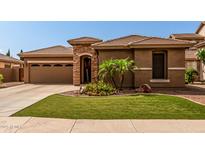 Inviting home exterior features a stone accent entry, three car garage, and manicured landscaping at 241 W Roadrunner Dr, Chandler, AZ 85286