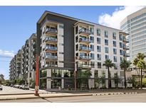 Modern apartment building with gray and white facade, balconies, and manicured landscaping on a sunny day at 3131 N Central Ave # 3009, Phoenix, AZ 85012