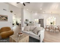 Bright, open-concept living room with modern decor flows into a kitchen and dining area, perfect for entertaining at 325 N Redrock St, Gilbert, AZ 85234