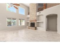 Open-concept living room showcasing a stone fireplace and large windows at 4801 E Quien Sabe Way, Cave Creek, AZ 85331