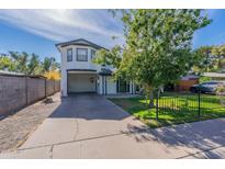 Two-story home features an attached carport, a well-maintained lawn, and mature landscaping at 505 W Howe St, Tempe, AZ 85281