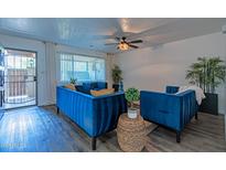Bright living room with blue velvet furniture and wood-look flooring at 6044 W Augusta Ave, Glendale, AZ 85301