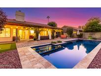 Inviting backyard pool area with covered patio and lush greenery illuminated by stylish string lights at dusk at 650 E Silver Creek Rd, Gilbert, AZ 85296