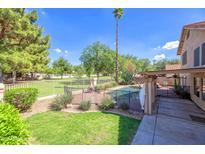 Beautiful backyard with a lush lawn, sparkling pool, and charming outdoor fire pit at 715 N Cholla St, Chandler, AZ 85224