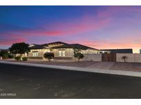 Beautiful single-story home with desert landscaping and warm exterior lighting at dusk at 9445 W Monte Lindo --, Peoria, AZ 85383