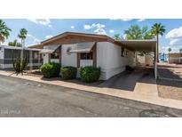 Cozy mobile home with awnings, carport, landscaping, and a paved driveway at 9501 E Broadway Rd # 168, Mesa, AZ 85208