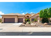 Charming single-story home showcasing a two-car garage, desert landscaping, and a tile roof at 14058 S 24Th Way, Phoenix, AZ 85048