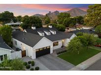 Stunning exterior of a modern farmhouse with black accents, mountain views, and beautiful landscaping at 3808 E Fairmount Ave, Phoenix, AZ 85018