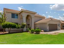 Spacious two-story home featuring a landscaped yard, archway entrance, and a two-car garage at 453 E Baylor Ln, Gilbert, AZ 85296