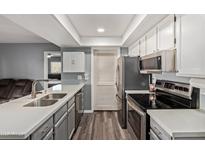 Bright kitchen features stainless steel appliances, gray cabinets and countertops, and wood-look floors at 520 N Stapley Dr # 256, Mesa, AZ 85203