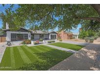 Charming home featuring a lush, green yard and an inviting exterior painted in classic white and black tones at 530 W Almeria Rd, Phoenix, AZ 85003