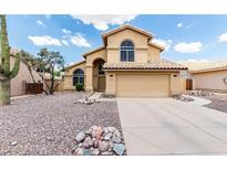 Inviting two-story home with a neutral stucco exterior, rock landscaping, and a tile roof for a stylish look at 6516 E Rochelle St, Mesa, AZ 85215