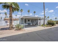 Charming single-story home with covered parking and front patio surrounded by desert landscaping at 7807 E Main St # H-27, Mesa, AZ 85207