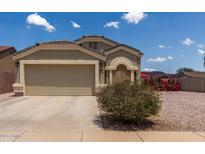 Charming single-story home features a two car garage and inviting curb appeal with desert landscaping and a blue sky backdrop at 1680 E Cardinal Dr, Casa Grande, AZ 85122